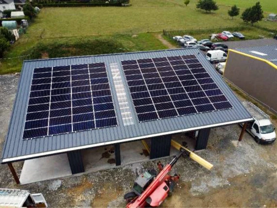 Chantier extérieur d'installation de panneaux photovoltaïques sur toiture métallique d'un bâtiment agricole ou industriel