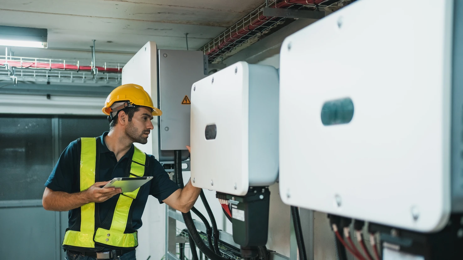 Technicien Ingénieur réglant le panneau solaire de l'onduleur dans la salle électrique