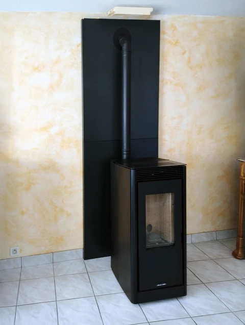 Intérieur résidentiel avec poêle à bois moderne noir installé contre un mur