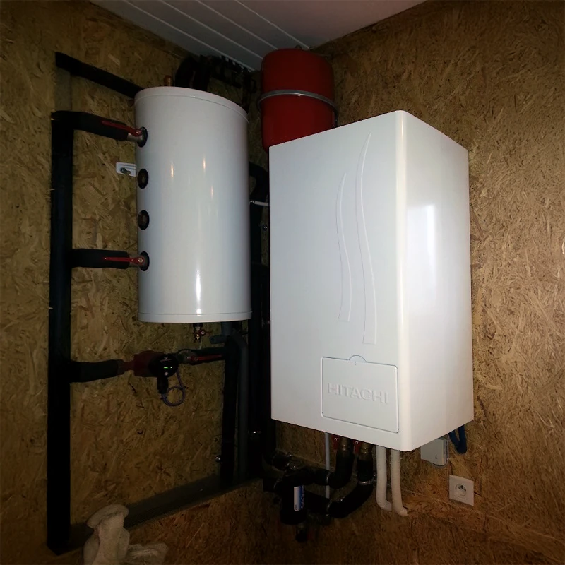 Chaufferie domestique avec chaudière murale blanche Hitachi installée sur mur en OSB