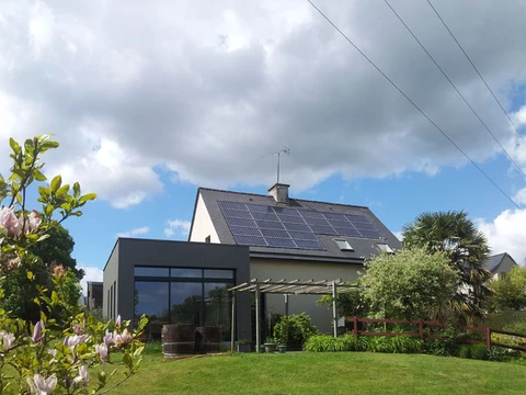 Maison résidentielle moderne avec extension contemporaine sous ciel nuageux