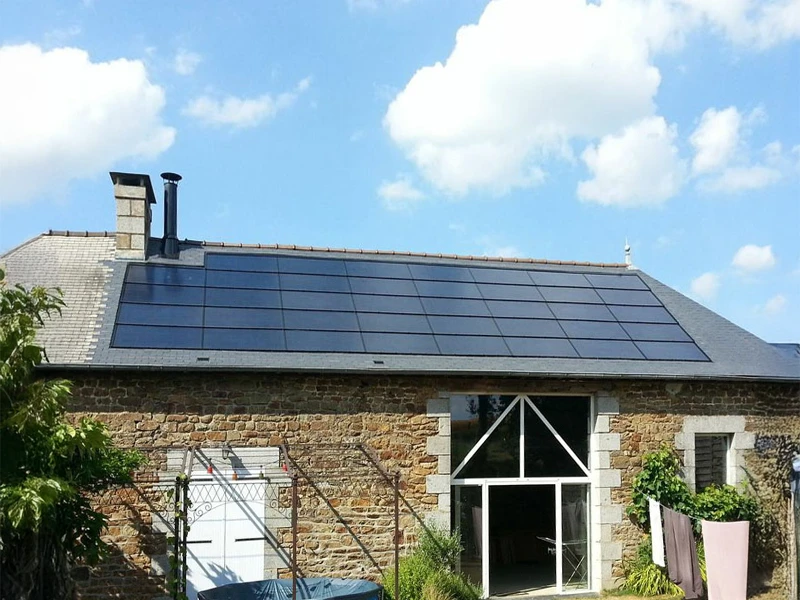 Maison résidentielle en pierre avec toiture équipée de panneaux solaires photovoltaïques